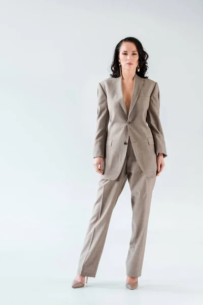 Stylish woman in suit looking at camera on grey background — Stock Photo