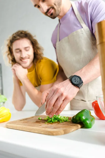 Селективное внимание бородатого гомосексуального мужчины, готовящего дома рядом с партнером — стоковое фото