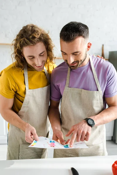 Happy homosexual men looking at colorful drawing — Stock Photo