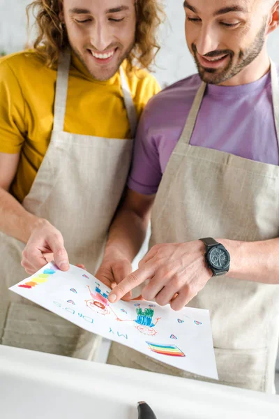 Feliz homosexual los hombres mirando colorido dibujo con mi papás letras - foto de stock