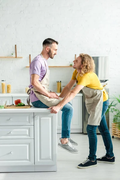 Profile of happy homosexual men looking at each other at home — Stock Photo