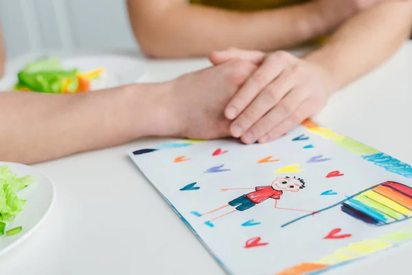Cropped view of homosexual men holding hands near drawing with lgbt flag — Stock Photo