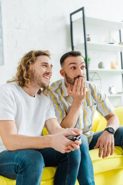 Красивые гомосексуальные мужчины смотрят телевизор в гостиной — стоковое фото