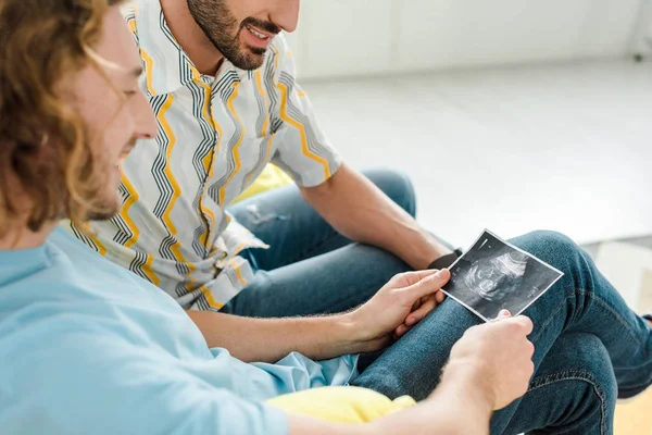 Selective focus of happy homosexual men looking at ultrasound scan — Stock Photo