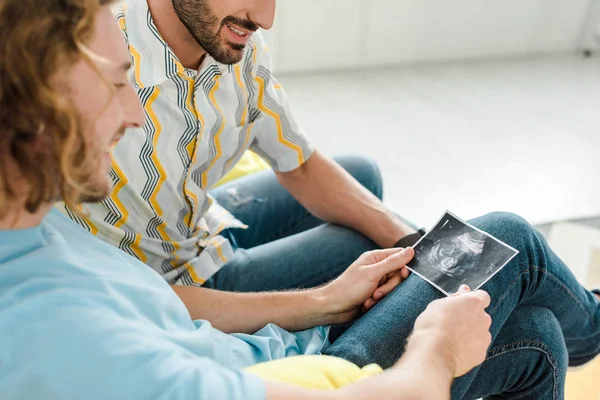 Foyer sélectif des hommes homosexuels heureux regardant l'échographie — Photo de stock