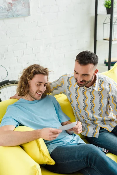 Hombres homosexuales felices mirando ultrasonido escaneo - foto de stock