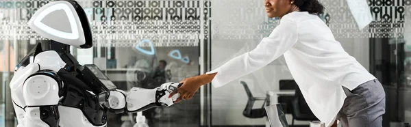 Panoramic shot of african american businesswoman shaking hands with robot in office — Stock Photo