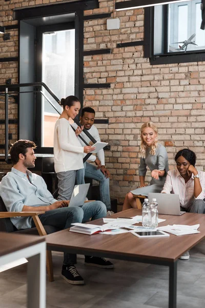 Giovani imprenditori multiculturali con gadget che hanno brainstorming in ufficio — Foto stock