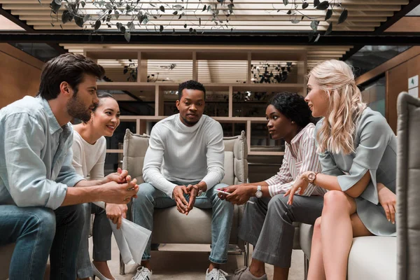 Junge multikulturelle Geschäftsleute sitzen während eines Treffens in der Lounge-Zone — Stockfoto