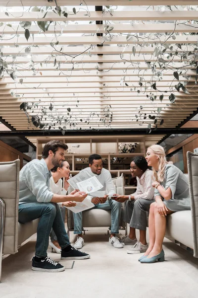 Young multicultural businesspeople sitting in office lounge while having discussion — Stock Photo