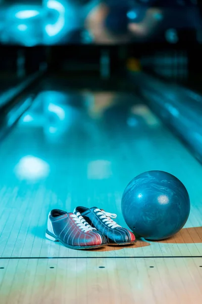 Selective focus of bowling shoes and ball on bowling alley — Stock Photo