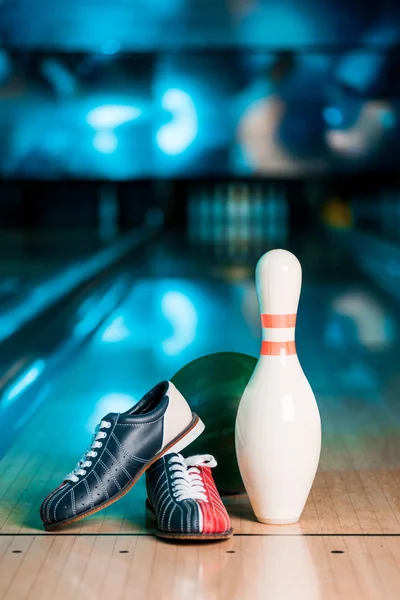Selektiver Fokus von Bowlingschuhen, Ball und Kegeln auf der Kegelbahn — Stockfoto