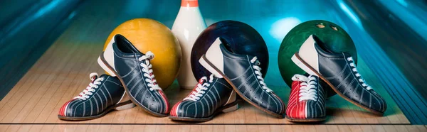 Panoramic shot of bowling shoes, balls and skittles in bowling club — Stock Photo