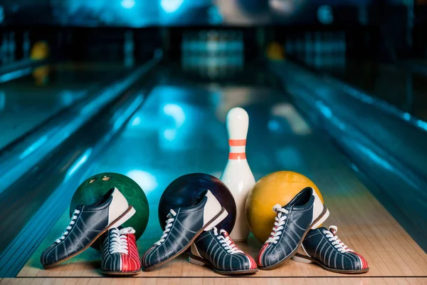 Focus selettivo di scarpe da bowling, palle e skittle su skittle alley nel bowling club — Foto stock