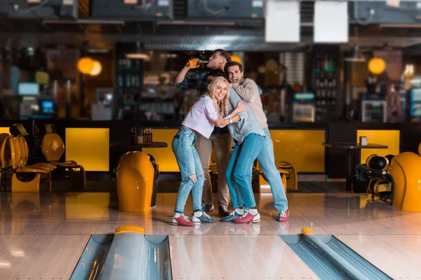 Amigos animados olhando para skittle beco enquanto jogando boliche juntos — Fotografia de Stock