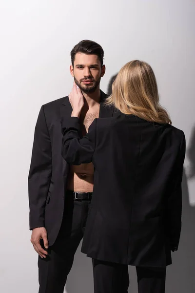 Vue arrière de la femme touchant homme barbu sur blanc — Photo de stock