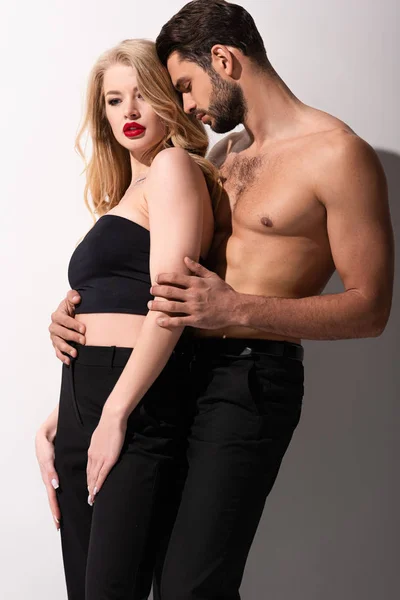 Shirtless man standing with stylish and beautiful girl on white — Stock Photo