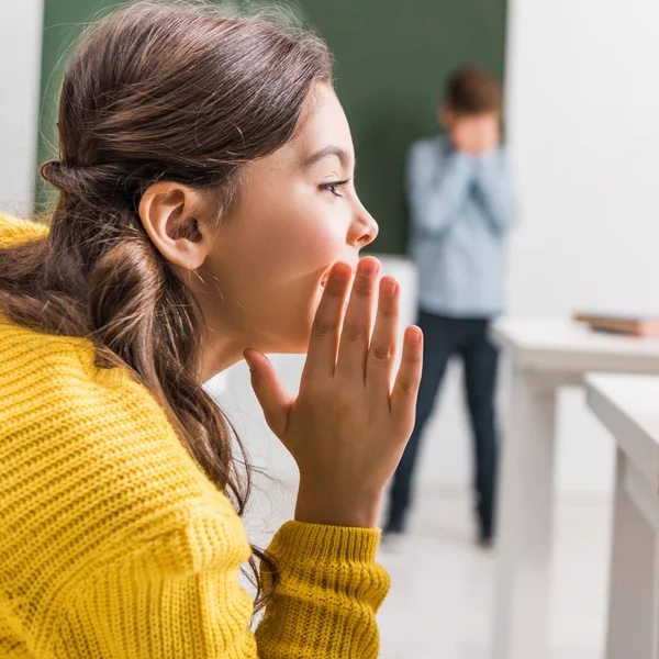 Foyer sélectif de commérages écolière près de camarade de classe bouleversé — Photo de stock