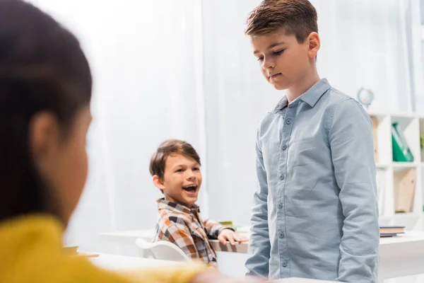 Foyer sélectif des écoliers heureux regardant écolier bouleversé, concept d'intimidation — Photo de stock