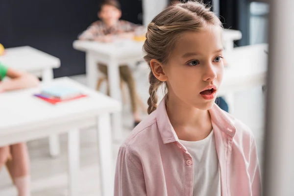 Selective focus of surprised schoolgirl standing in classroom, bullying concept — Stock Photo