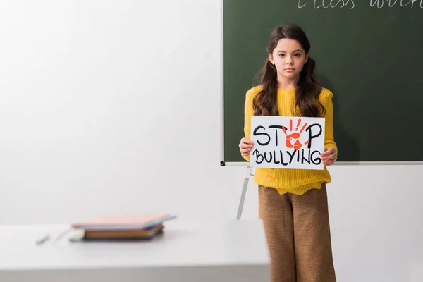 Foco seletivo da estudante segurando cartaz com letras stop bullying — Fotografia de Stock