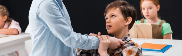 Panoramic shot of schoolkid bullying classmate near schoolgirls — Stock Photo