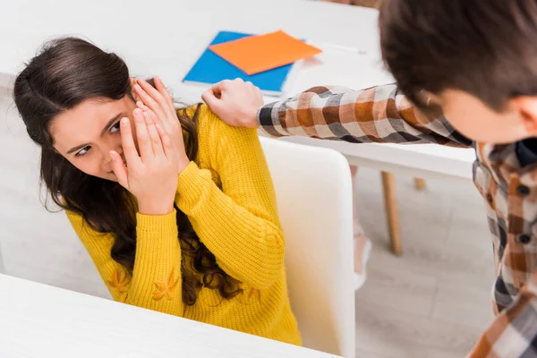 Selective focus of cruel schoolboy bullying scared schoolgirl in classroom — Stock Photo