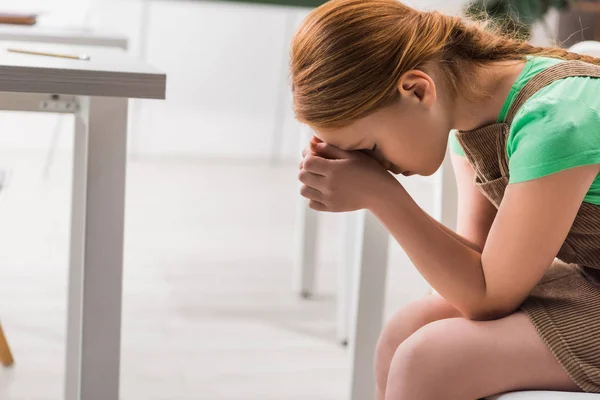 Frustrated and bullied schoolgirl sitting in classroom — Stock Photo