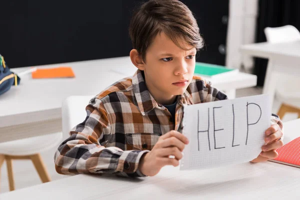 Selective focus of sad schoolboy holding paper with help lettering, bullying concept — Stock Photo