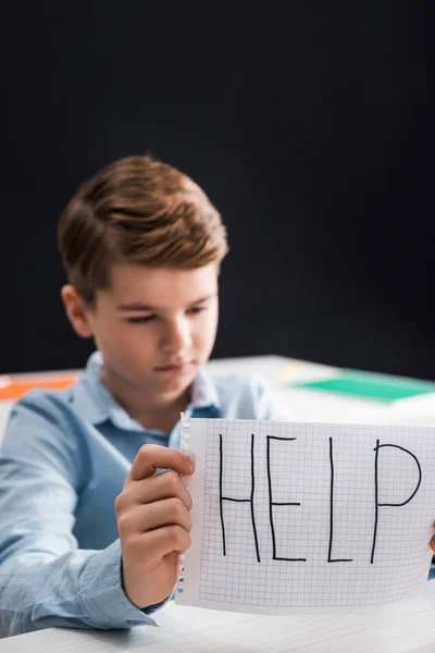 Selective focus of frustrated schoolkid holding paper with help lettering, bullying concept — Stock Photo