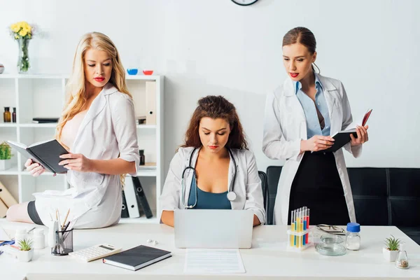 Enfermeras jóvenes y sexy que trabajan en la clínica moderna - foto de stock