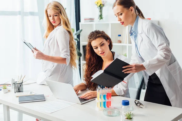 Smart and sexy nurses in white coats working in clinic — Stock Photo