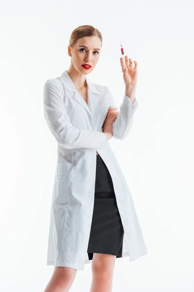 Infirmière sexy en manteau blanc tenant seringue isolé sur blanc — Photo de stock