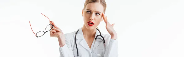 Panoramic shot of pensive sexy nurse holding glasses and looking away isolated on white — Stock Photo