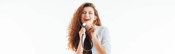 Tiro panorámico de enfermera feliz y sexy usando estetoscopio aislado en blanco - foto de stock