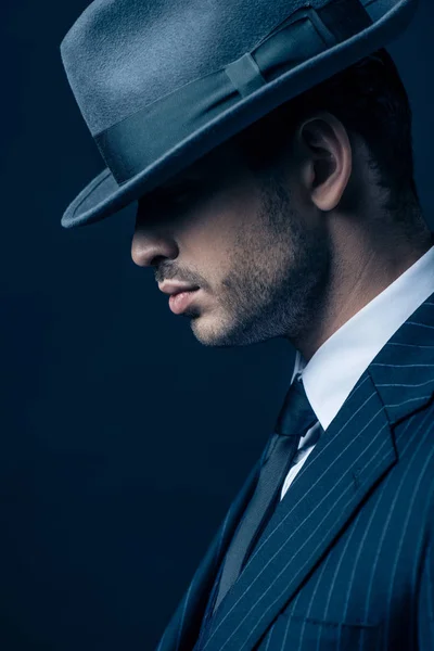 Profil de mafioso en costume et chapeau en feutre sur fond foncé — Photo de stock