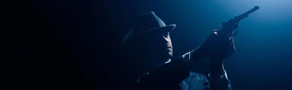 Gangster zielt Revolver auf dunklen Hintergrund, Panoramaaufnahme — Stockfoto