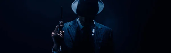 Silhouette of gangster raising gun on dark blue background, panoramic shot — Stock Photo