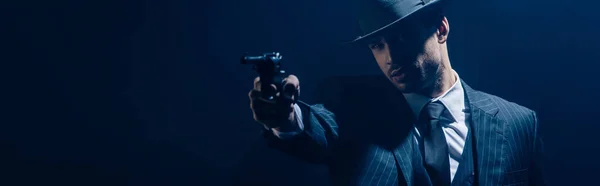 Arme de visée gangster avec la main tendue sur fond sombre, tir panoramique — Photo de stock