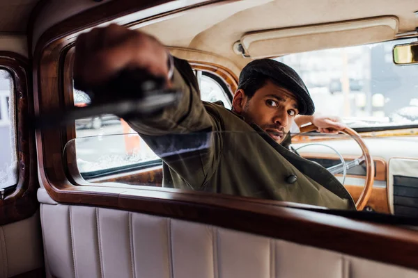 Selective focus of dangerous gangster aiming gun in car — Stock Photo