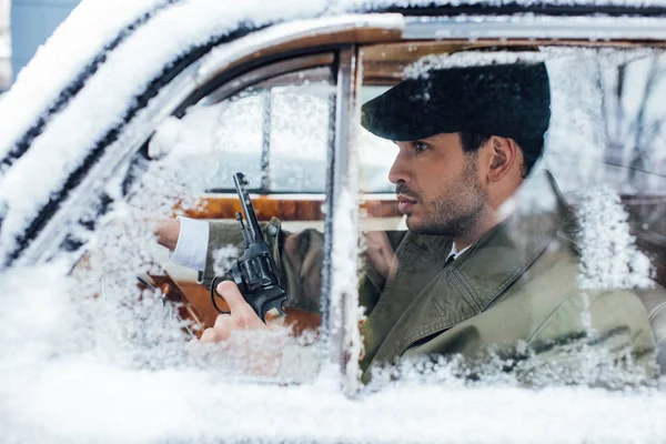 Selective focus of dangerous gangster with gun driving car — Stock Photo