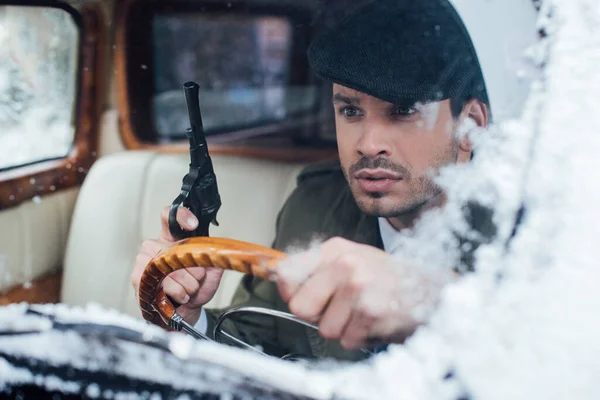 Selective focus of dangerous mafioso with weapon driving car — Stock Photo