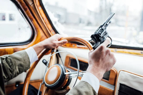 Vue recadrée du mafieux tenant le pistolet et la voiture de conduite — Photo de stock