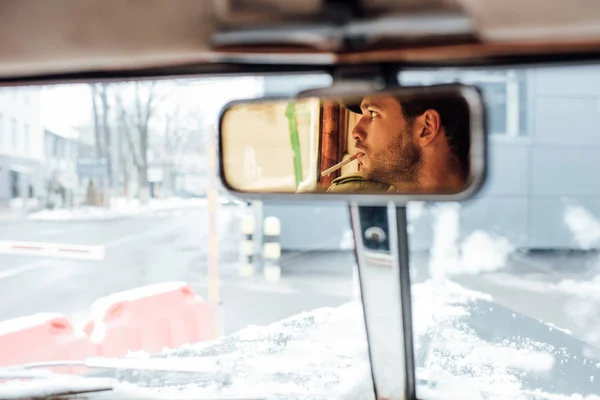 Foco seletivo de reflexão mafioso na visão traseira espelho fumar no carro — Fotografia de Stock