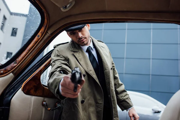 Enfoque selectivo de arma de tiro mafiosa con la mano extendida en el coche retro — Stock Photo