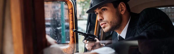 Selektiver Fokus des Gangsters, der mit Waffe im Retro-Auto im Hinterhalt sitzt, Panoramaaufnahme — Stockfoto