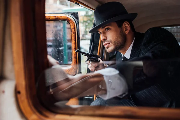 Selektiver Fokus von Gangster sitzt mit Waffe im Retro-Auto im Hinterhalt — Stockfoto
