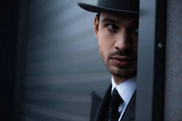 Enfoque selectivo de mafioso mirando desde la esquina en la calle — Stock Photo