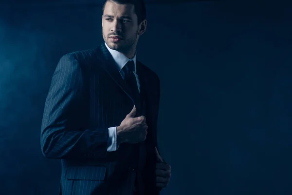 Confident mafioso looking away on dark blue background — Stock Photo