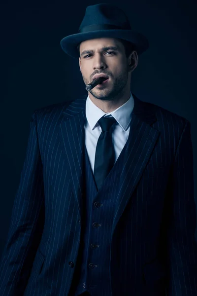 Front view of mafioso smoking cigar on dark blue — Stock Photo